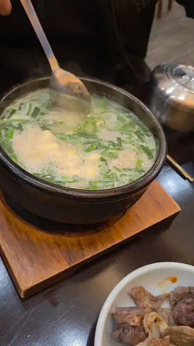 얼큰한 국물에 숟가락을 넣는 모습