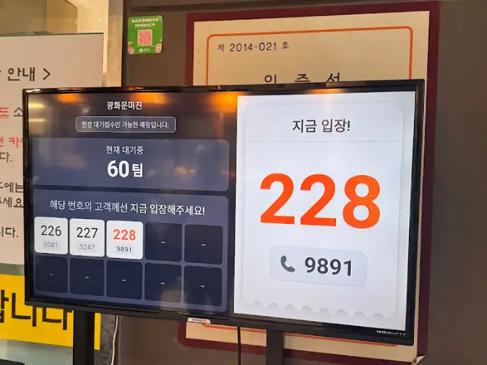매장 입구의 대기 안내 시스템 화면. 현재 대기 팀 수와 번호가 표시되어 있다.