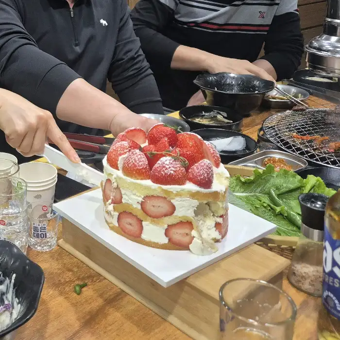 딸기가 듬뿍 올라간 케이크를 자르고 있는 모습