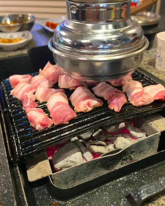 불판 위에서 맛있게 익어가는 두툼한 삼겹살