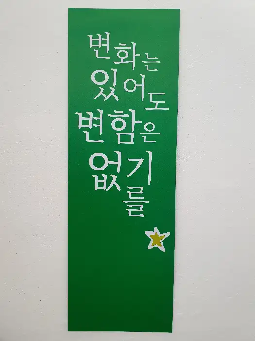 초록색 배경에 흰색 한글 글귀가 적힌 현수막
