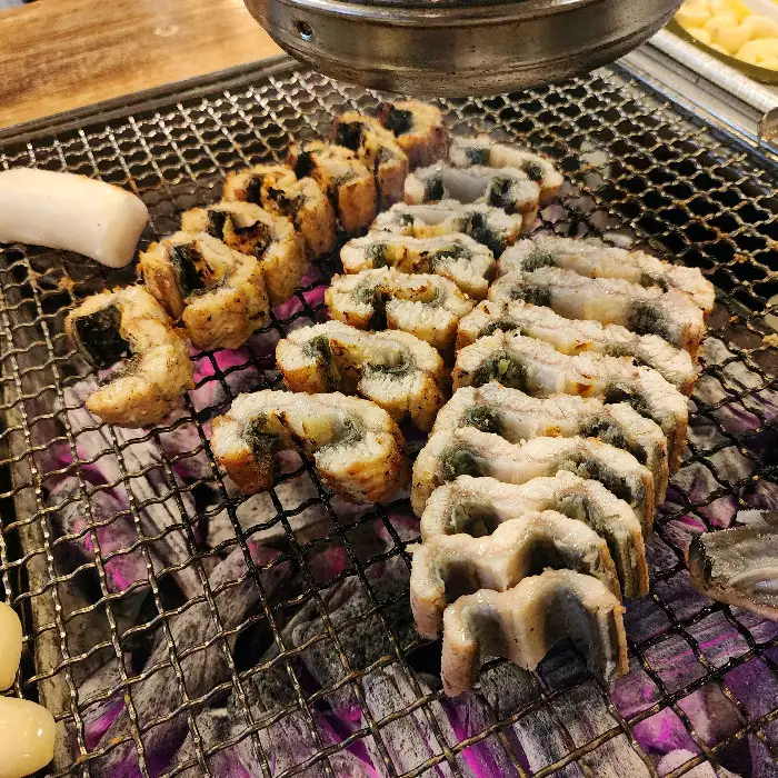 숯불 위에서 노릇하게 구워지는 두툼한 장어구이