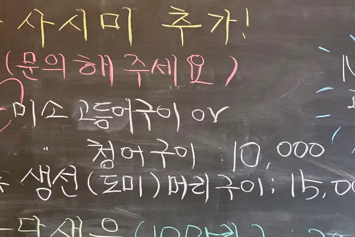 메뉴판에 다양한 해산물 요리 이름과 가격이 적혀 있습니다.