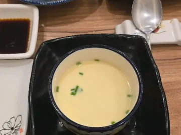고급스러운 그릇에 담긴 따뜻한 계란찜과 곁들임 찬