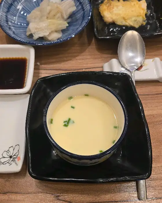 고급스러운 그릇에 담긴 따뜻한 계란찜과 곁들임 찬