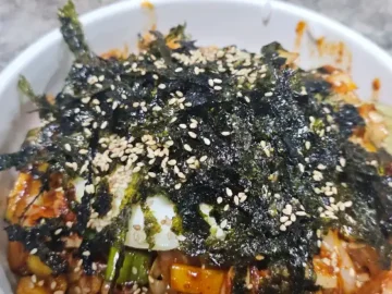 김이 모락모락 나는 중화비빔밥에 김가루와 깨가 듬뿍 뿌려진 모습