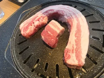 육일관 본점의 두툼한 통삼겹살이 불판 위에 올려져 있습니다.