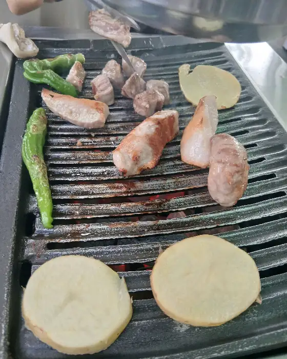 잘 달궈진 불판 위에서 고기와 채소가 익어가고 있는 모습