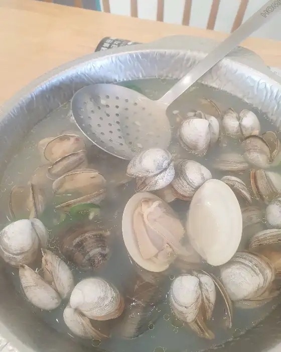 국자로 조개를 건져 올리는 도브레만돌 샤브샤브