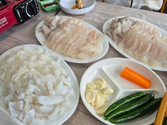 테이블 위에 차려진 다양한 종류의 회와 곁들임 찬, 휴대용 버너