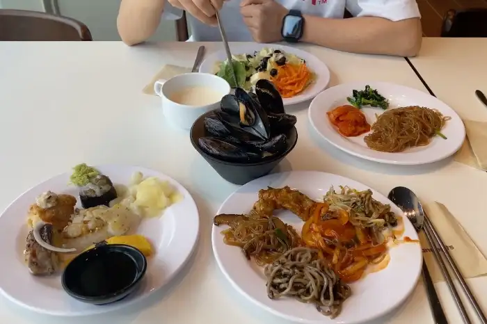 다양한 샐러드와 해산물, 그리고 파스타가 놓인 테이블