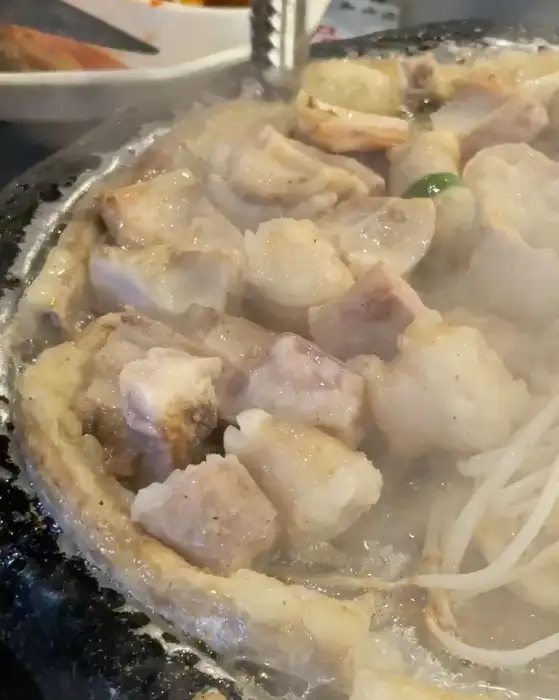 곱창, 대창, 막창이 지글지글 익어가는 모습. 기름이 지글거리고 김이 모락모락 나는 것이 맛있어 보입니다.