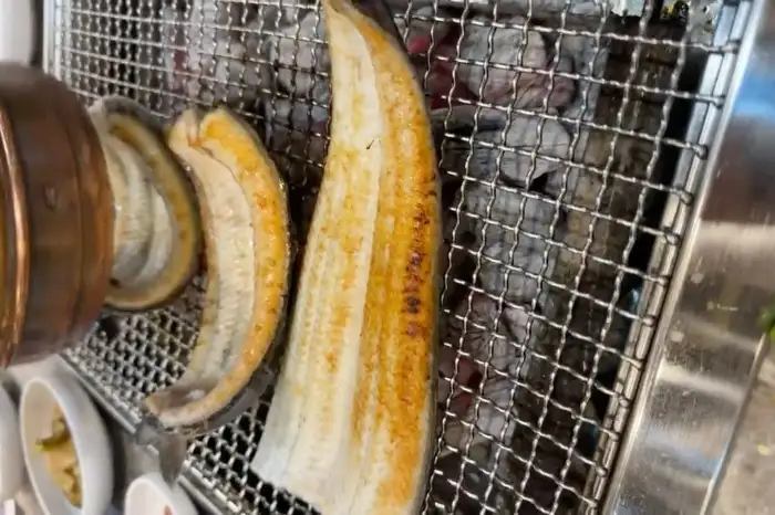숯불 위에서 노릇하게 구워지고 있는 장어의 모습