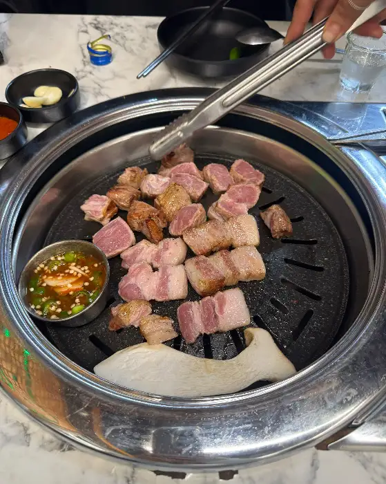 집게로 집어 올린 흑돼지 조각들