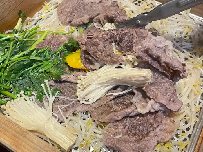 집게로 집어 올린 편백찜 속 소고기
