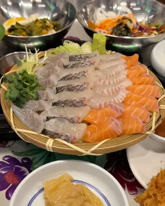붉은 연어와 흰살 생선이 겹겹이 쌓인 먹음직스러운 모듬회