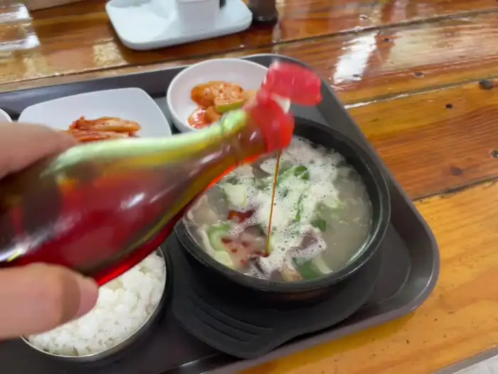 해장국에 양념을 더하는 모습