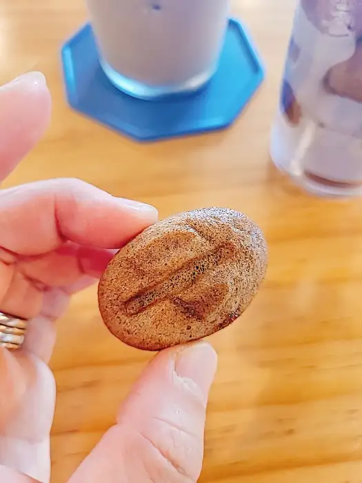손으로 커피콩빵을 들고 있는 모습