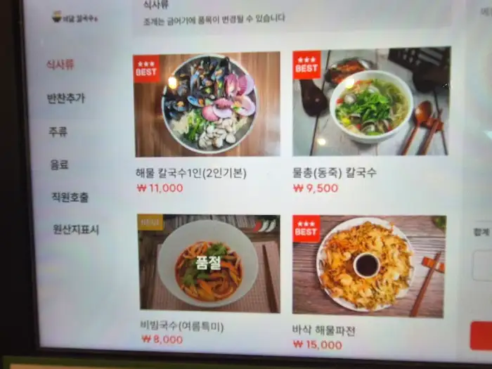 바담칼국수 메뉴판에서 해물칼국수와 물만두를 보여주는 모습