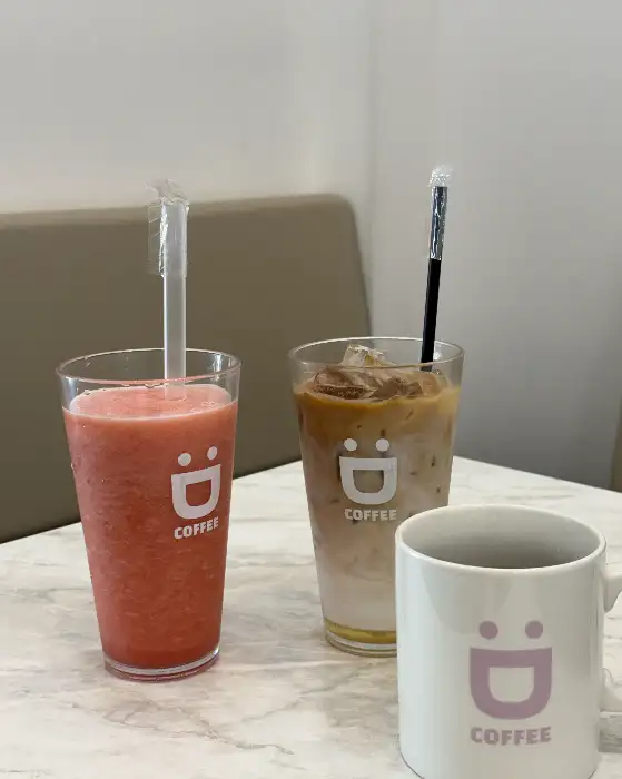 진열대에 놓인 딸기 스무디, 아이스 라떼, 커피잔