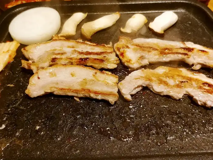 불판 위에서 맛있게 구워지고 있는 대관령쌈밥의 삼겹살