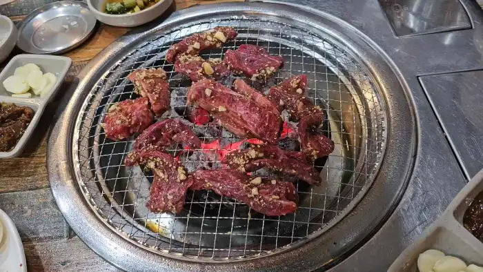 소고기 살치살 여러 점이 숯불 위에서 익어가고 있는 모습