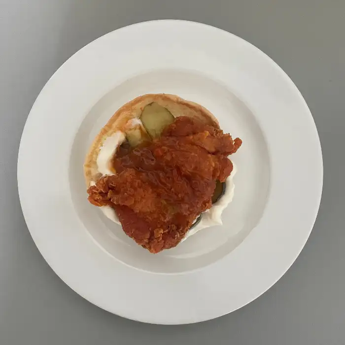접시에 담긴 치킨버거의 단면