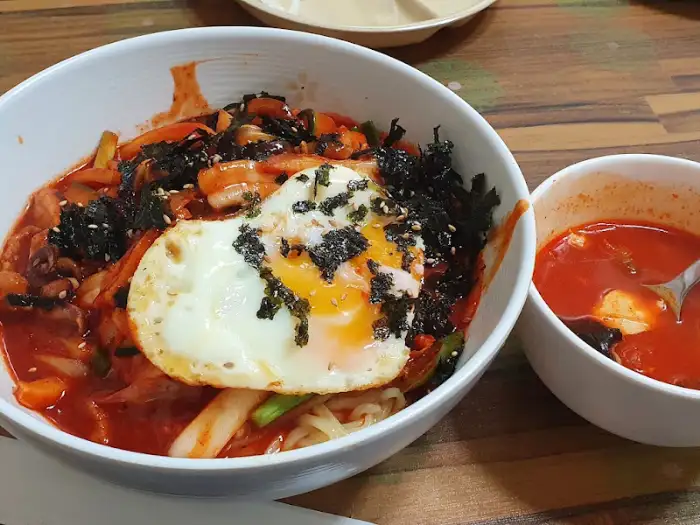 계란 프라이와 김가루, 채소 등이 푸짐하게 올라간 비빔면