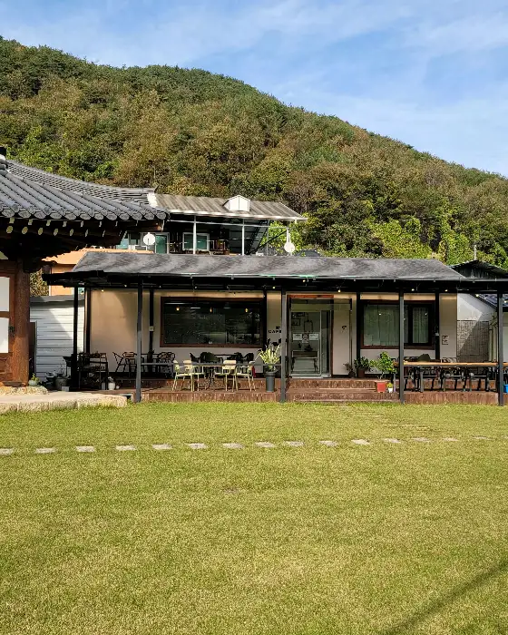언덕에 위치한 카페 소나무의 전경과 주변 자연 경관