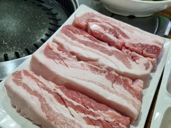 신선한 삼겹살이 푸짐하게 담겨 나온 접시