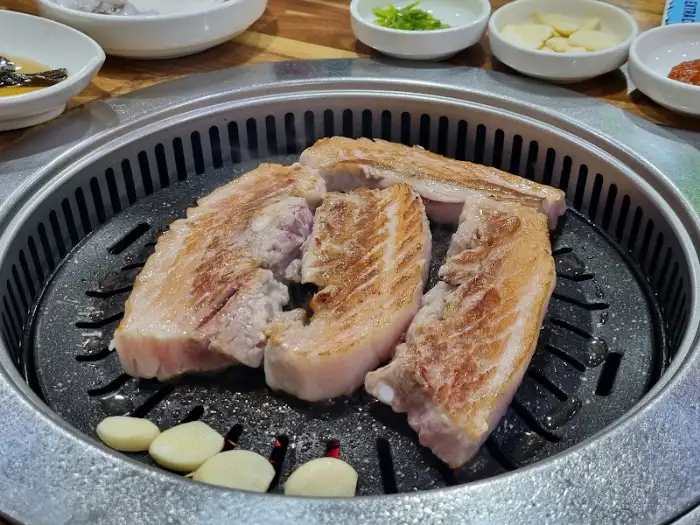 참숯골에서 삼겹살이 불판 위에서 익어가고 있는 모습
