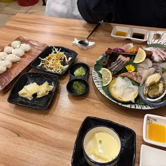 다양한 종류의 숙성회와 해산물, 레몬 슬라이스가 보기 좋게 담긴 플레이트