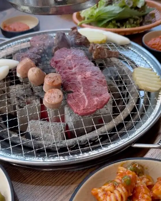 숯불 위에서 익어가는 소고기와 소세지