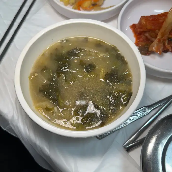 푸른 잎 채소가 가득 담긴 맑은 국물