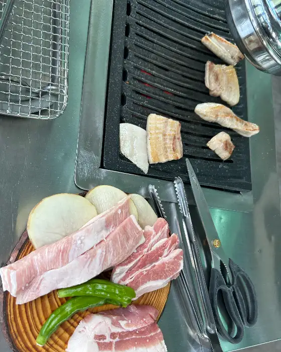 신선한 생갈비살과 껍데기가 불판 위에서 구워지고 있는 모습