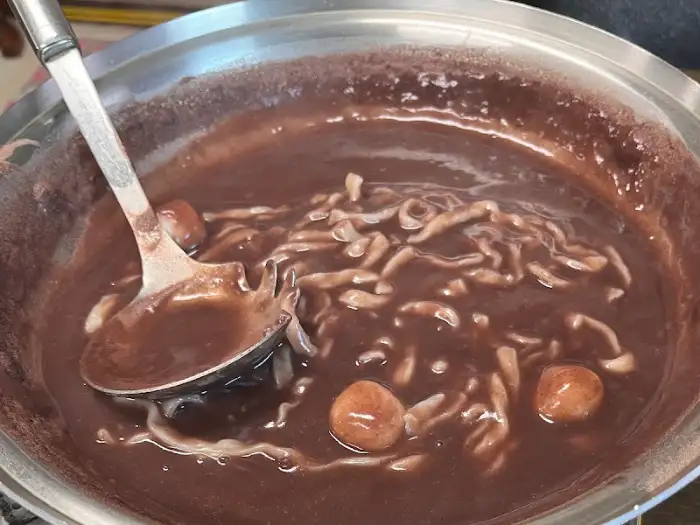 따뜻한 팥죽 위에 쫄깃한 면과 팥알갱이가 든 모습