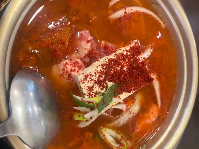 동인동한옥집김치찜의 김치찌개, 붉은 국물에 두부와 파가 어우러져 있습니다.