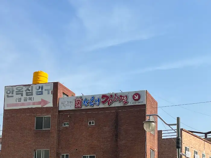 동인동한옥집김치찜 간판, 하늘을 배경으로 붉은 벽돌 건물에 걸려 있습니다.