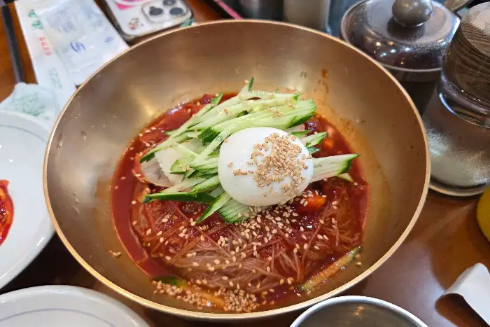 잘 비벼진 함흥식 비빔냉면에 올라간 계란 지단과 오이채