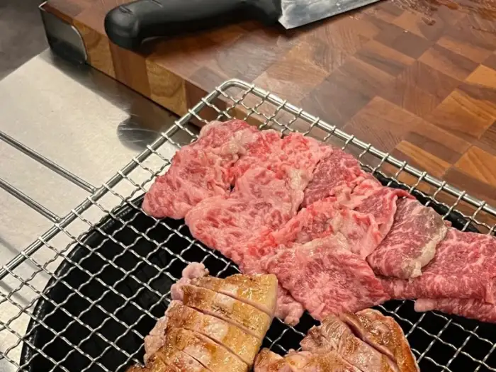 철제 꼬치에 담겨 숯불 위에서 구워지고 있는 지방이 풍부한 소고기
