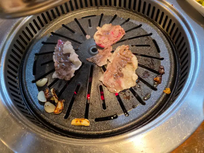 그릴 위에서 구워지는 신선한 소고기 조각들