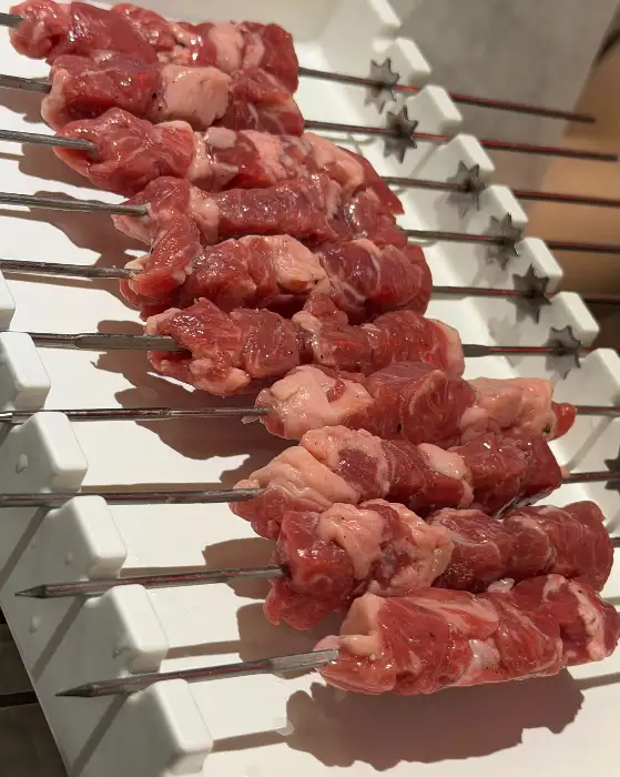 신선한 생양꼬치가 숯불에 구워질 준비를 하고 있습니다.