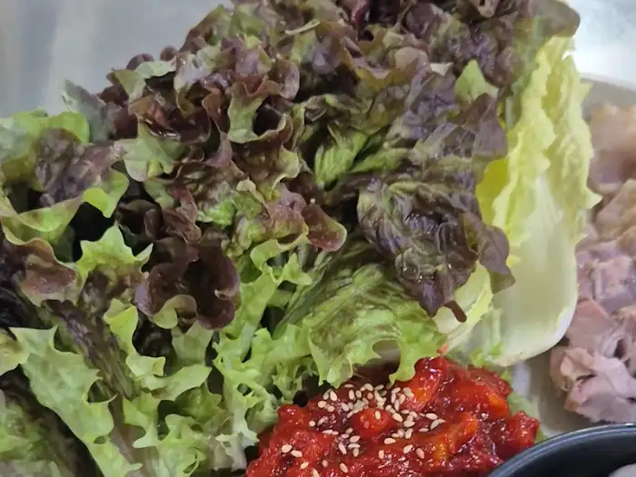 신선한 쌈채소와 곁들임 소스가 담긴 굴보쌈 한 상 차림