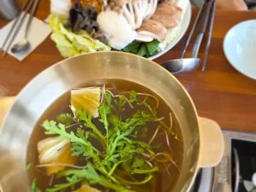 따뜻한 육수에 신선한 채소와 버섯이 담긴 샤브샤브 냄비