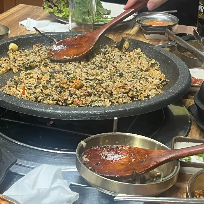 불판 위에서 볶아지고 있는 밥과 야채, 고기가 어우러진 메뉴