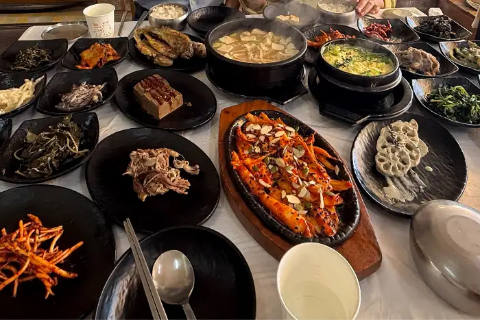 다양한 종류의 나물 반찬과 메인 요리, 밥, 국 등이 푸짐하게 차려진 산나물밥상 한정식