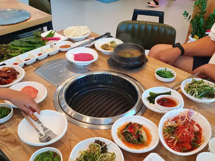 온정정육식당의 푸짐한 식탁, 다양한 반찬과 쌈 채소가 가득