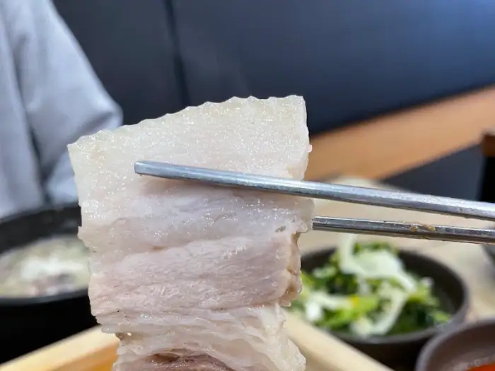집게로 집은 고향옥 편백보쌈의 두툼한 살코기