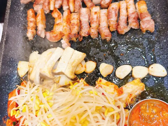 잘 구워지고 있는 삼겹살과 곁들임 채소