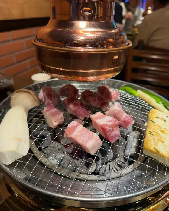 참숯 위에서 맛있게 구워지는 금복왕소금구이의 삼겹살